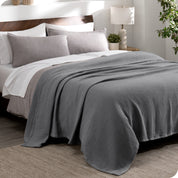 A cotton waffle blanket draped over a bed
