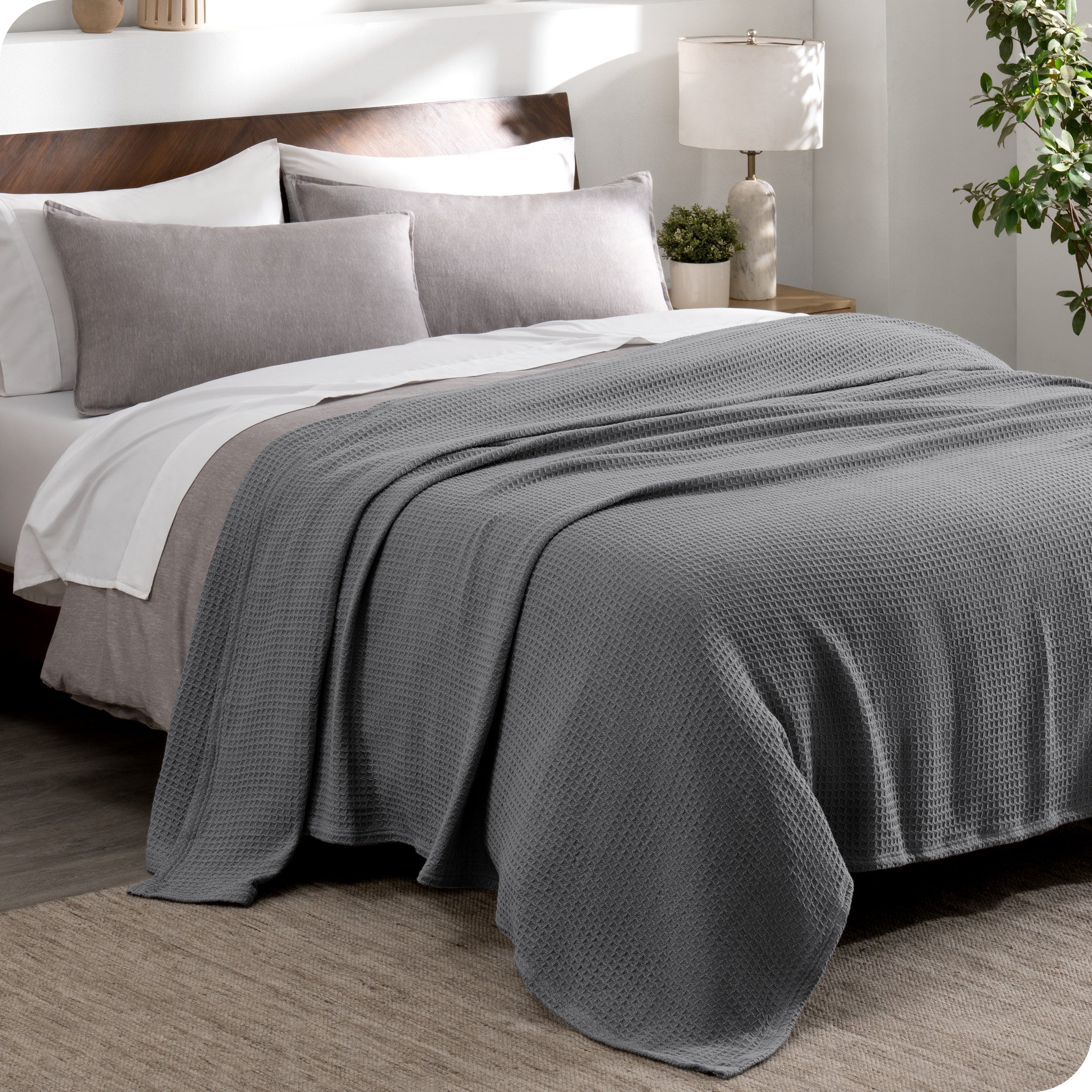 A cotton waffle blanket draped over a bed