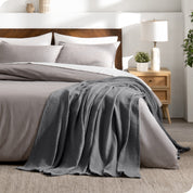A cotton waffle blanket on the corner of a bed