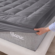 The corner of a mattress with a mattress pad putting on it