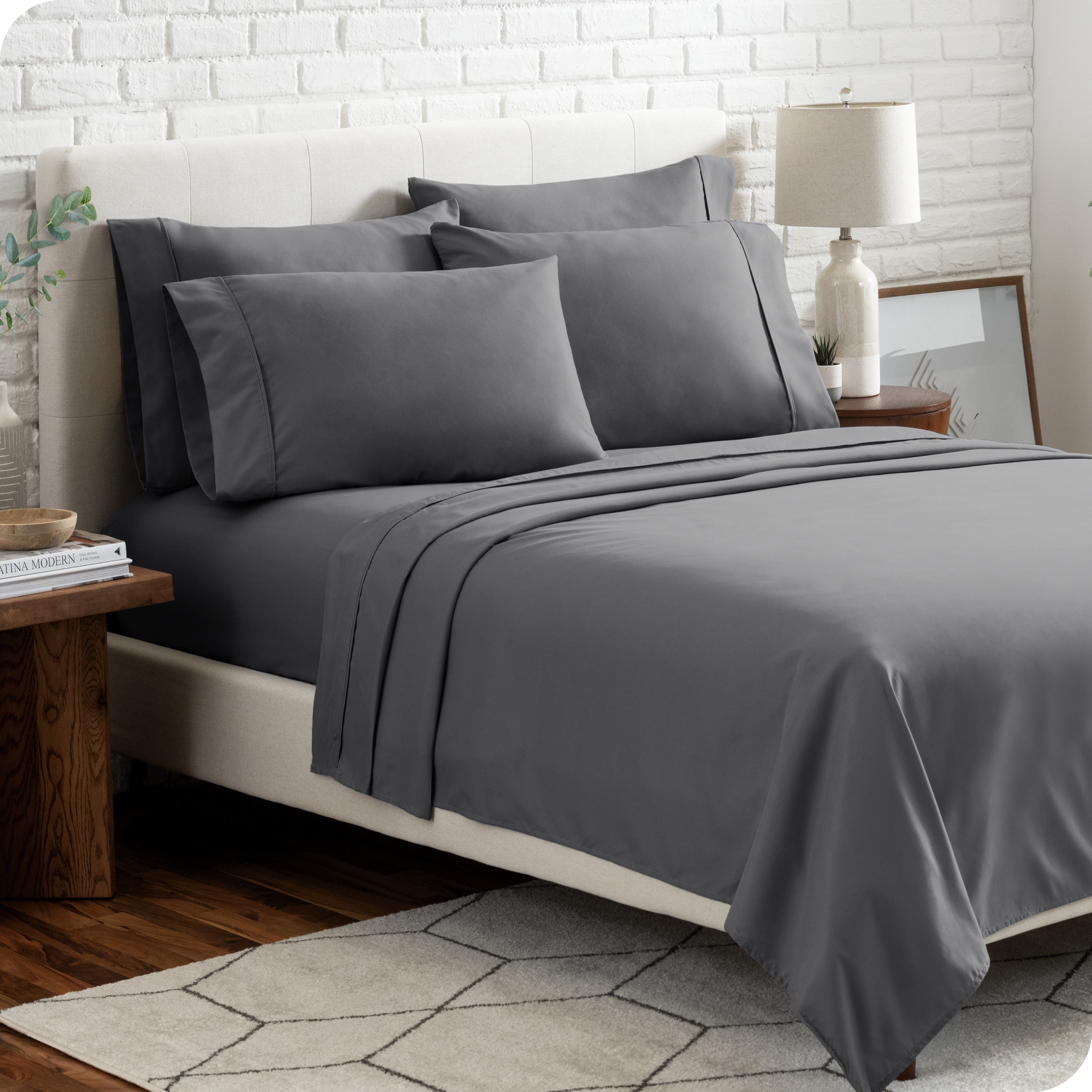 A bedroom setting with a bed made with the microfiber bed sheets and four pillows.