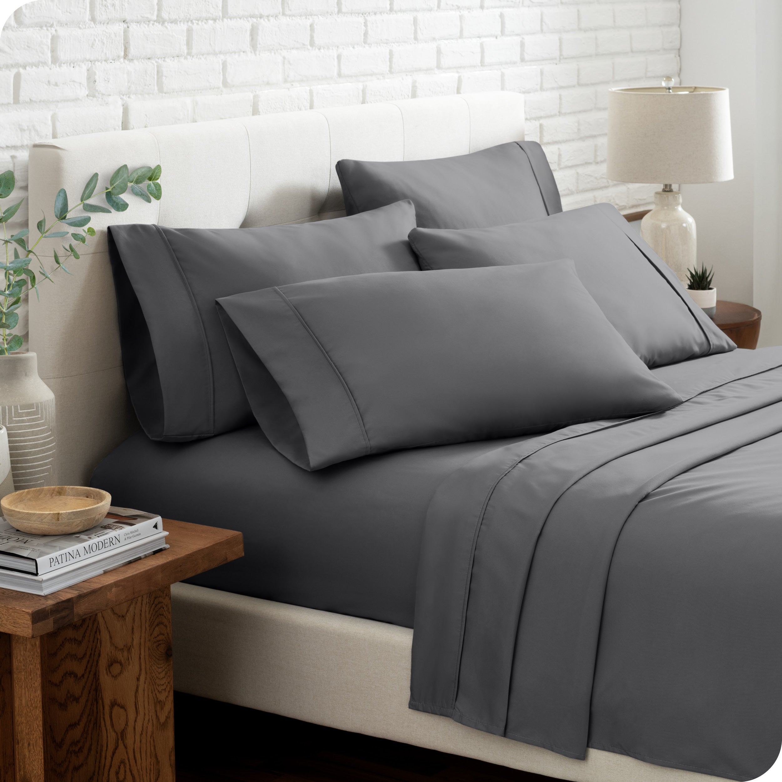 Close up of the microfiber bed sheets on a bed with four pillows.