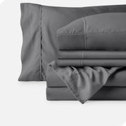 Microfiber sheets neatly folded with corner draped over, two folded pillowcases and two display pillows.