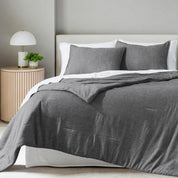 A comforter set on a bed in a bright modern room