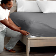 A modern bed with a fitted microfiber sheet on it