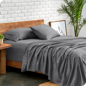 Microfiber sheets and matching pillowcases on a bed next to a large plant
