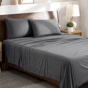 Stretch sheets on a bed with a wooden headboard in a bedroom setting.