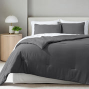 A comforter set on a bed in a bright modern room