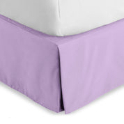 The corner of a bed skirt on a bed frame