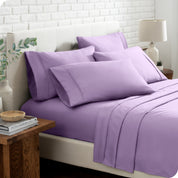 Close up of the microfiber bed sheets on a bed with four pillows.