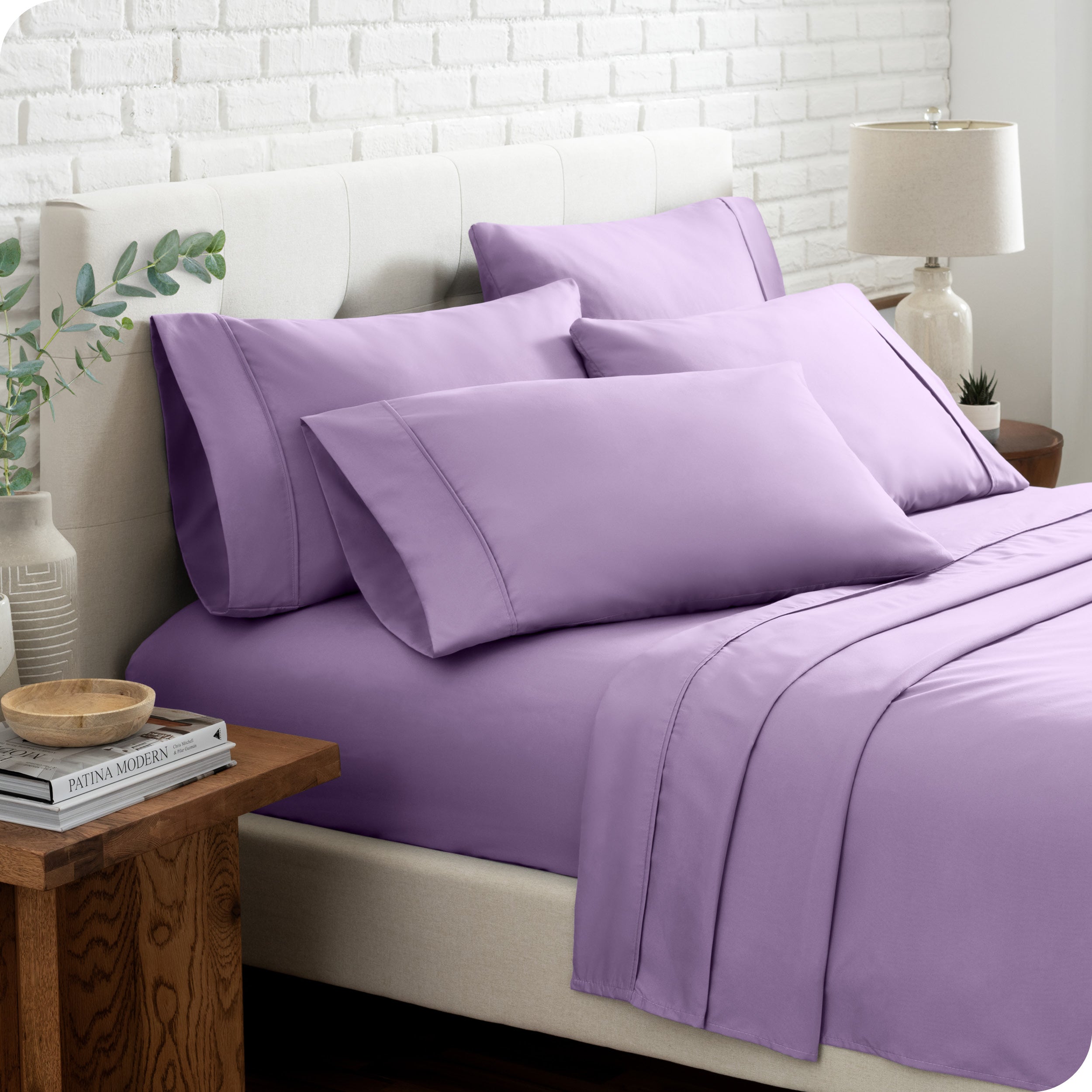 Close up of the microfiber bed sheets on a bed with four pillows.