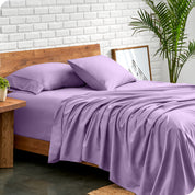 Microfiber sheets and matching pillowcases on a bed next to a large plant