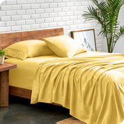 Microfiber sheets and matching pillowcases on a bed next to a large plant