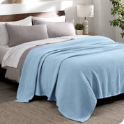 A cotton waffle blanket draped over a bed