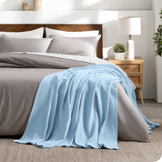 A cotton waffle blanket on the corner of a bed