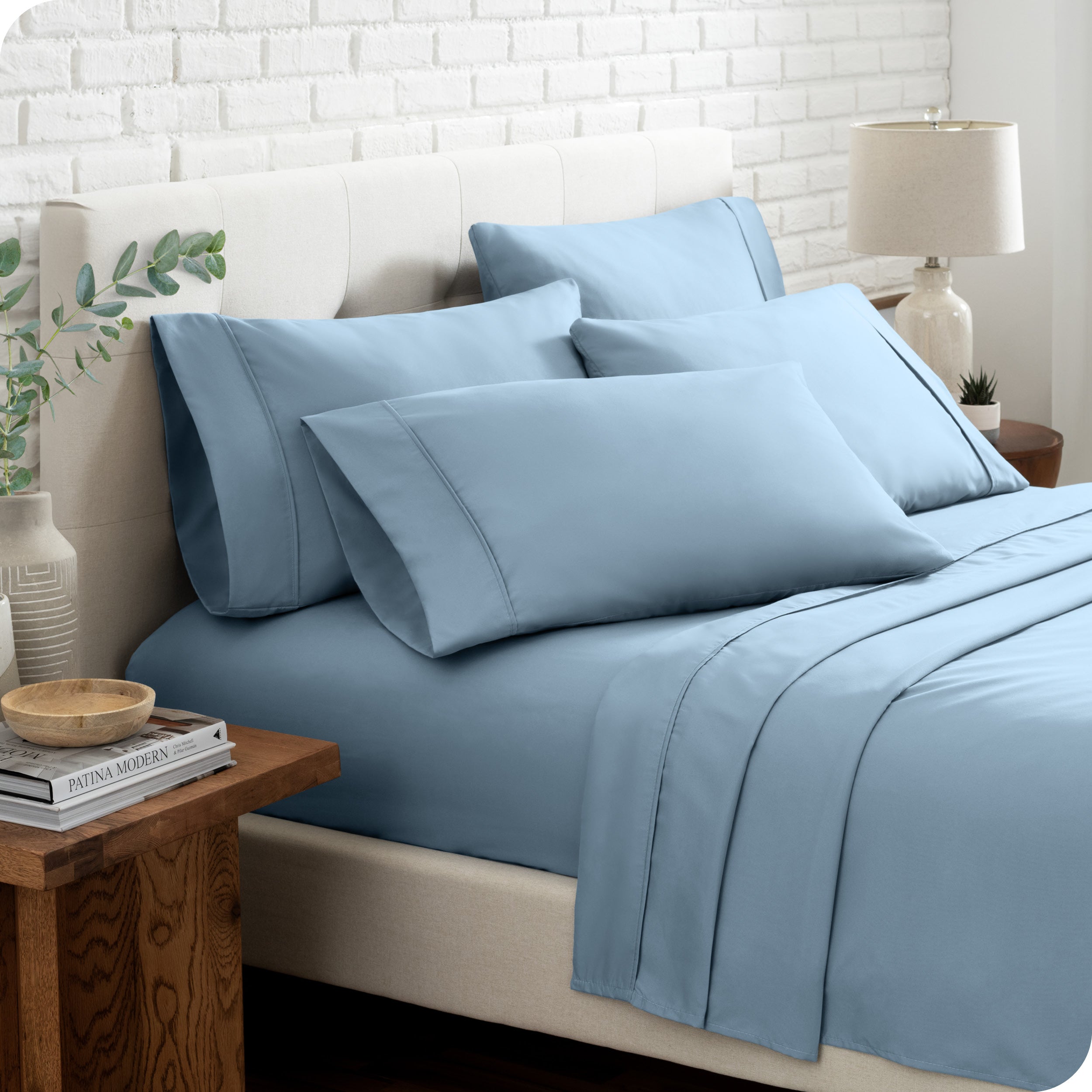 Close up of the microfiber bed sheets on a bed with four pillows.