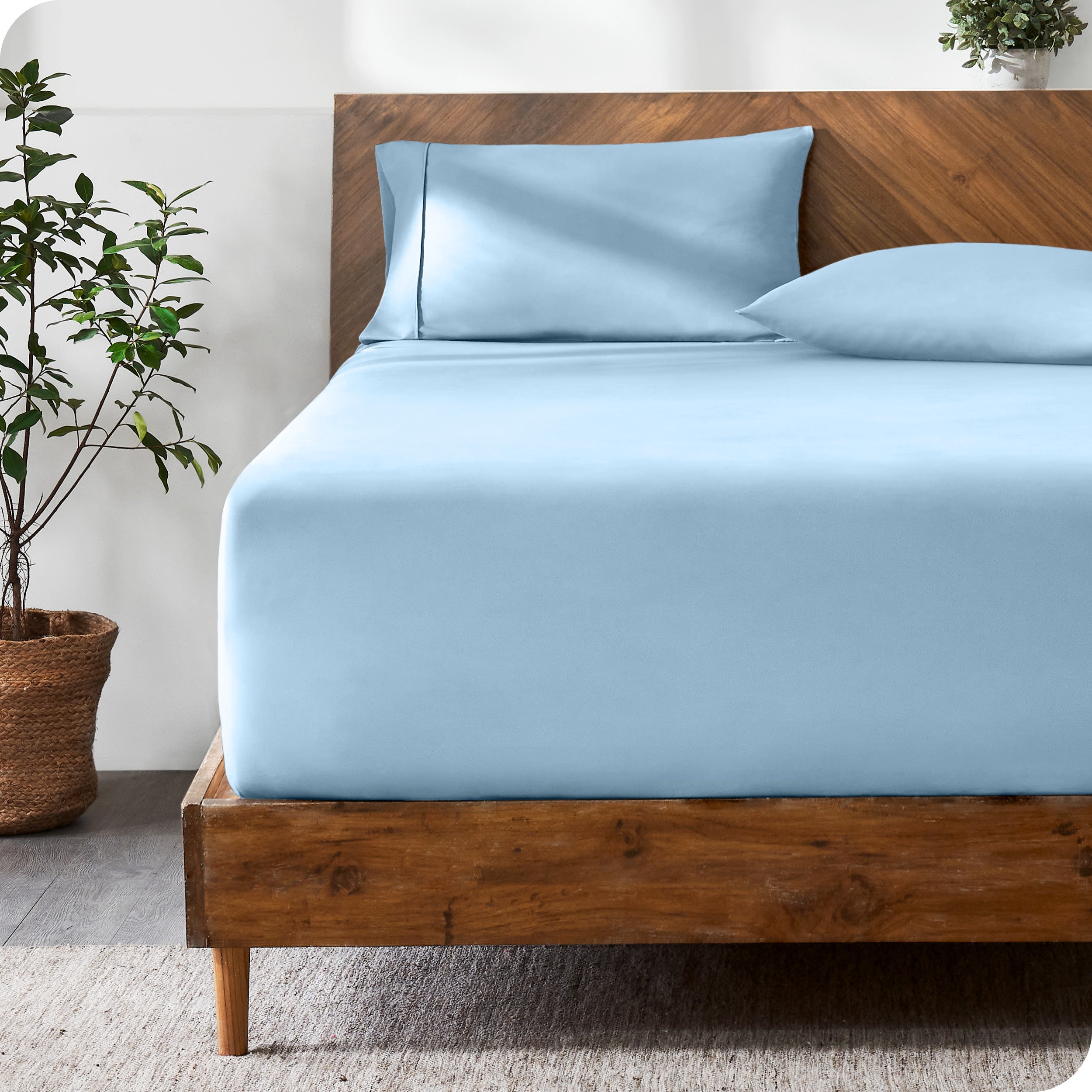 A modern bed with a fitted microfiber sheet made on the mattress.