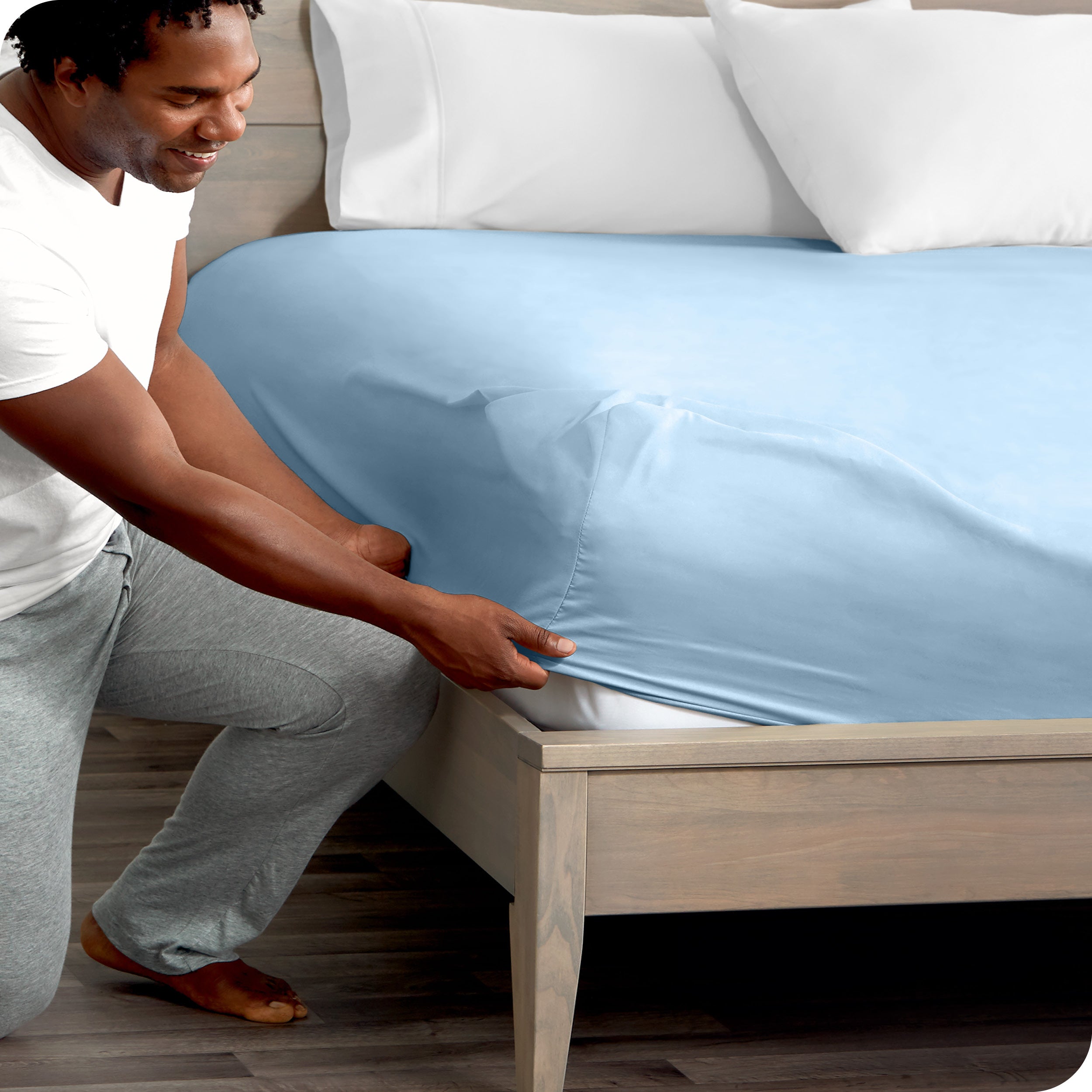 A modern bed with a fitted microfiber sheet on it