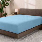 A sideview of a modern bed with a polar fleece fitted sheet on.