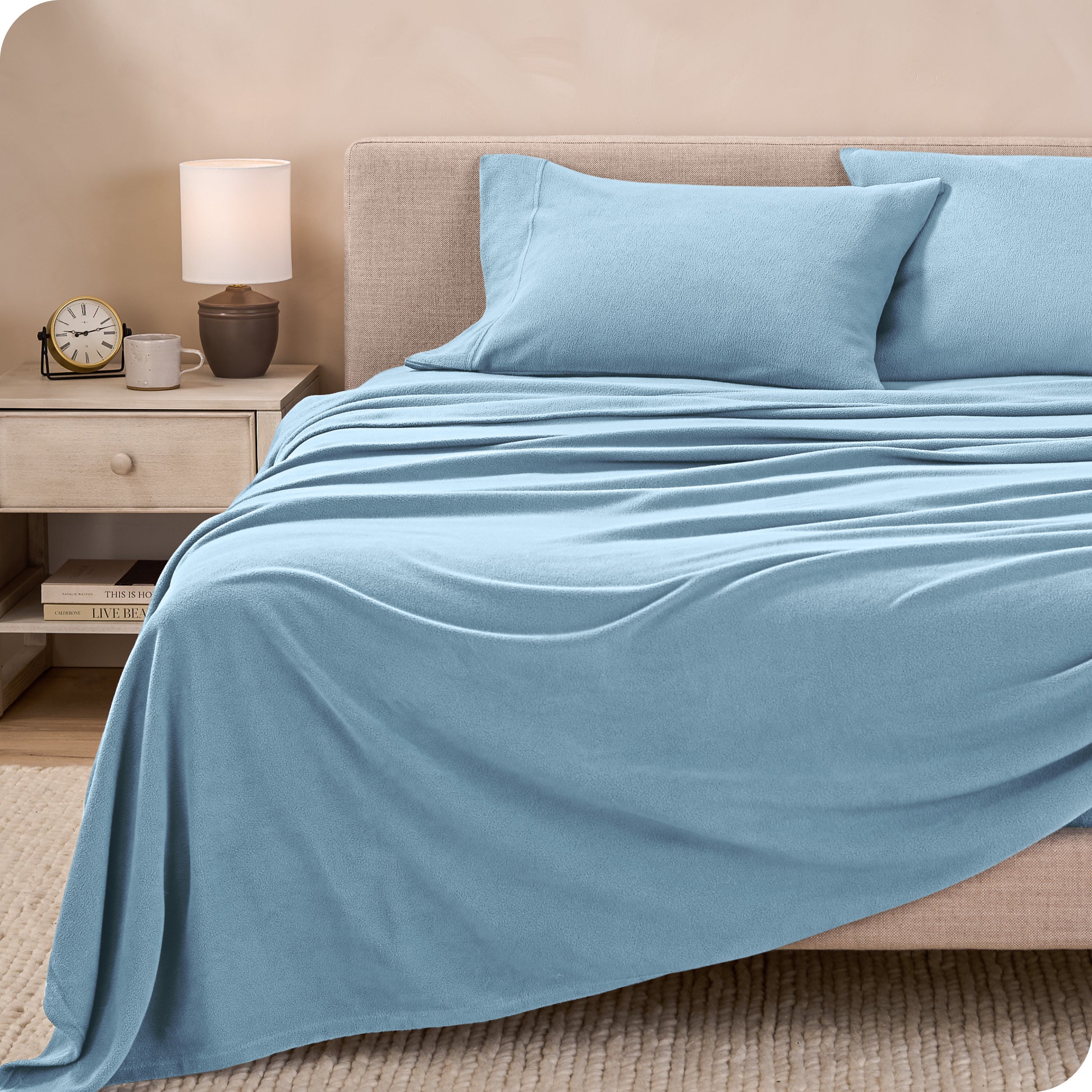 View of fleece sheets from the end of a bed with the top sheet draped over the side and end