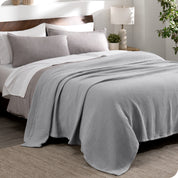 A cotton waffle blanket draped over a bed