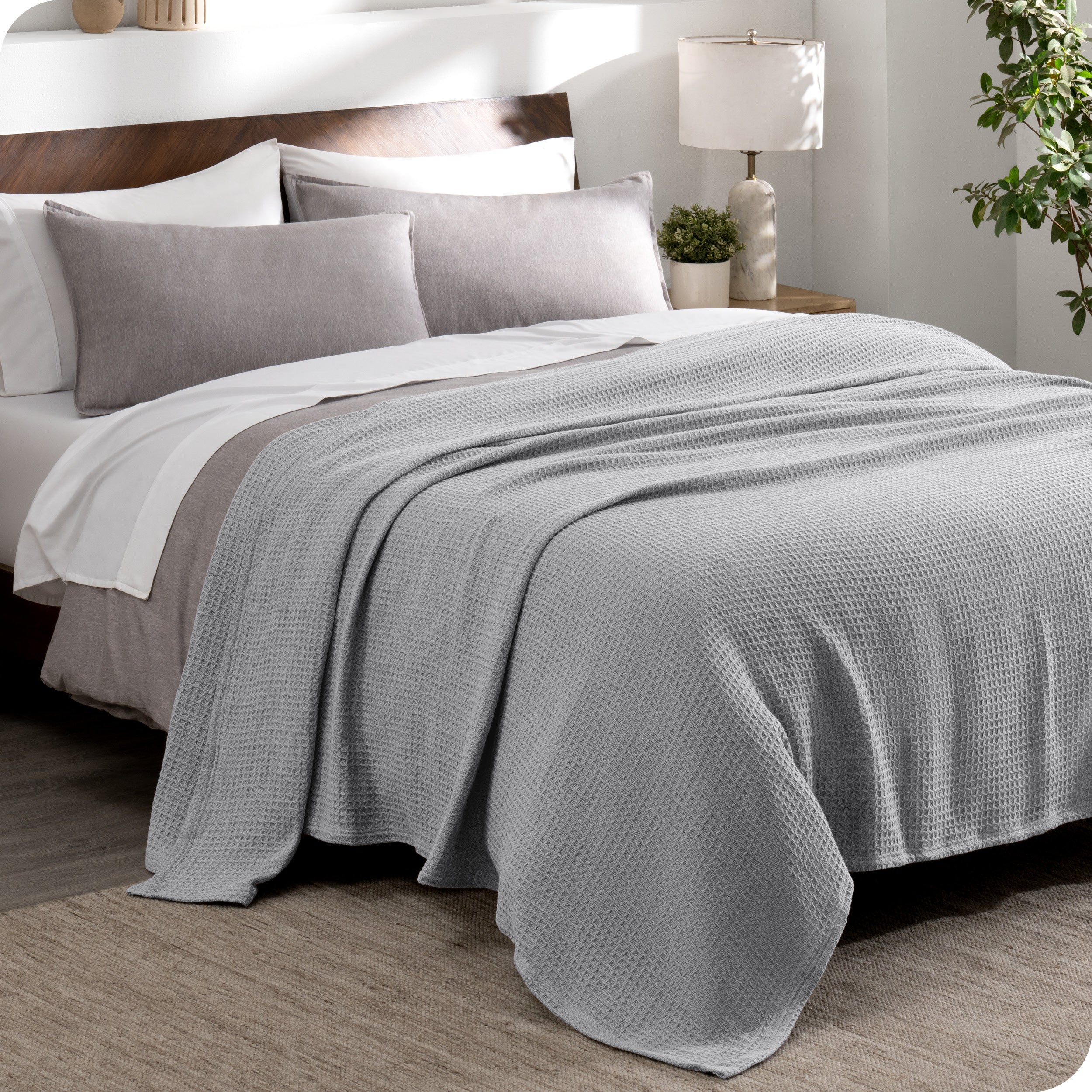 A cotton waffle blanket draped over a bed