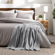 A cotton waffle blanket on the corner of a bed