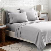 A bedroom setting with a bed made with the microfiber bed sheets and four pillows.