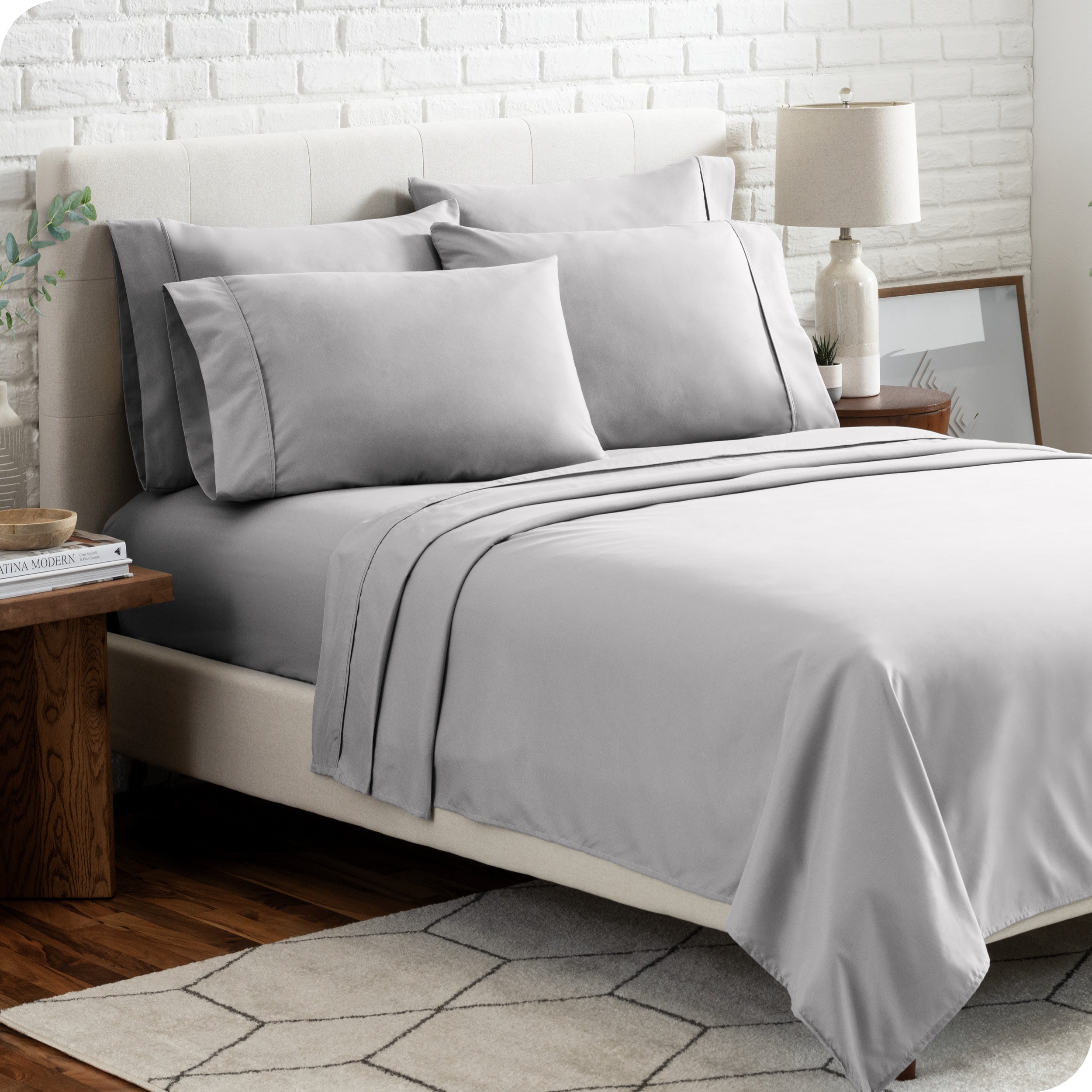 A bedroom setting with a bed made with the microfiber bed sheets and four pillows.