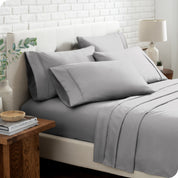 Close up of the microfiber bed sheets on a bed with four pillows.