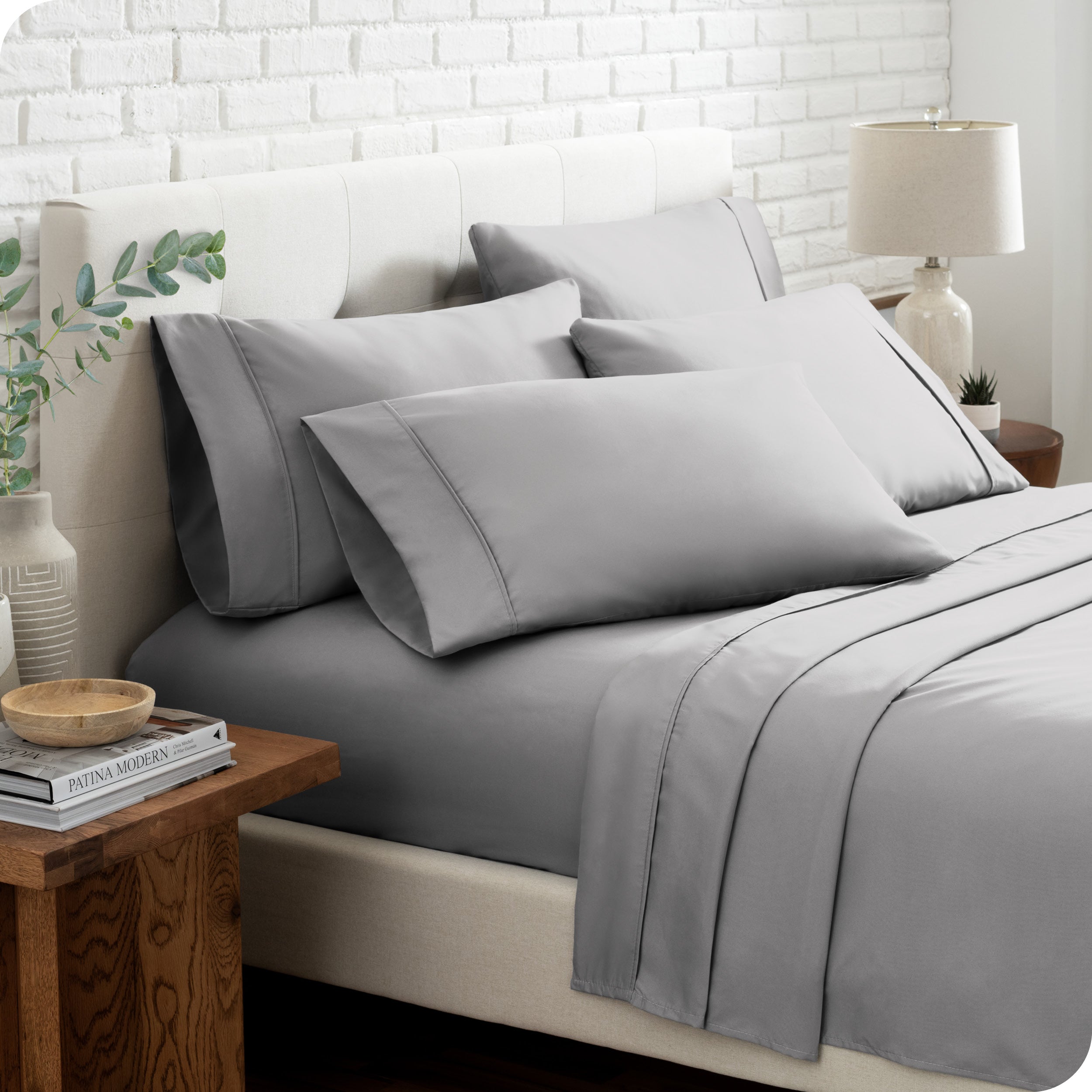 Close up of the microfiber bed sheets on a bed with four pillows.
