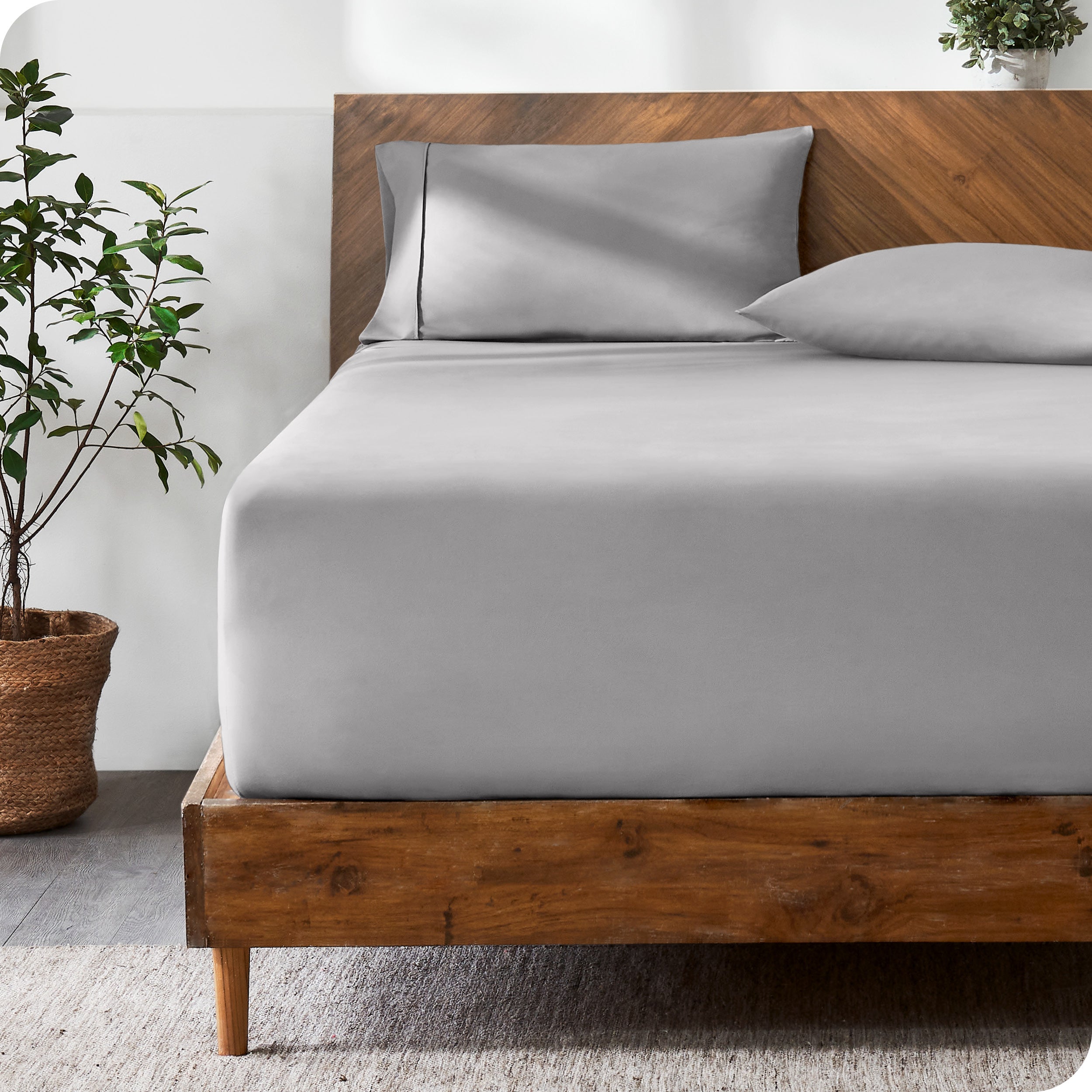 A modern bed with a fitted microfiber sheet made on the mattress.