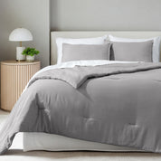 A comforter set on a bed in a bright modern room