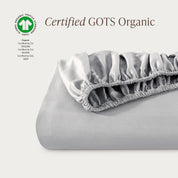 A single fitted sheet folded neatly showing part of the elastic. The fitted sheet is Certified GOTS Organic.