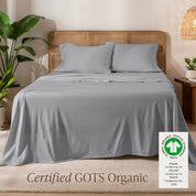 A bed in the middle of room with a set of Certified GOTS Organic Jersey Sheet Set on it.