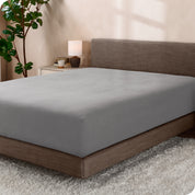 A sideview of a modern bed with a polar fleece fitted sheet on.