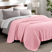 A cotton waffle blanket draped over a bed