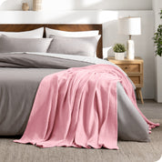 A cotton waffle blanket on the corner of a bed