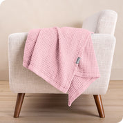 A cotton blanket on the arm of a chair
