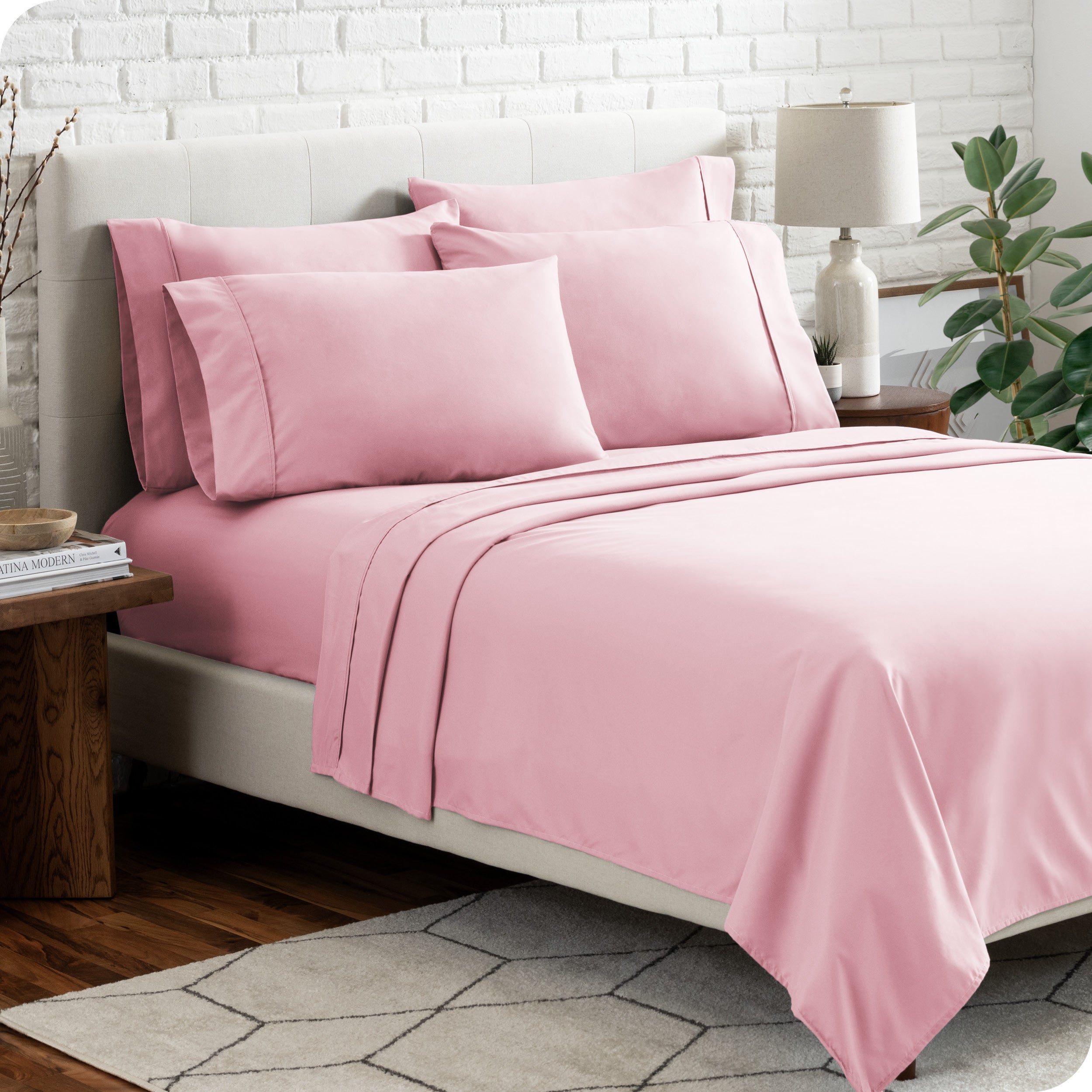 A bedroom setting with a bed made with the microfiber bed sheets and four pillows.