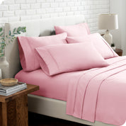 Close up of the microfiber bed sheets on a bed with four pillows.