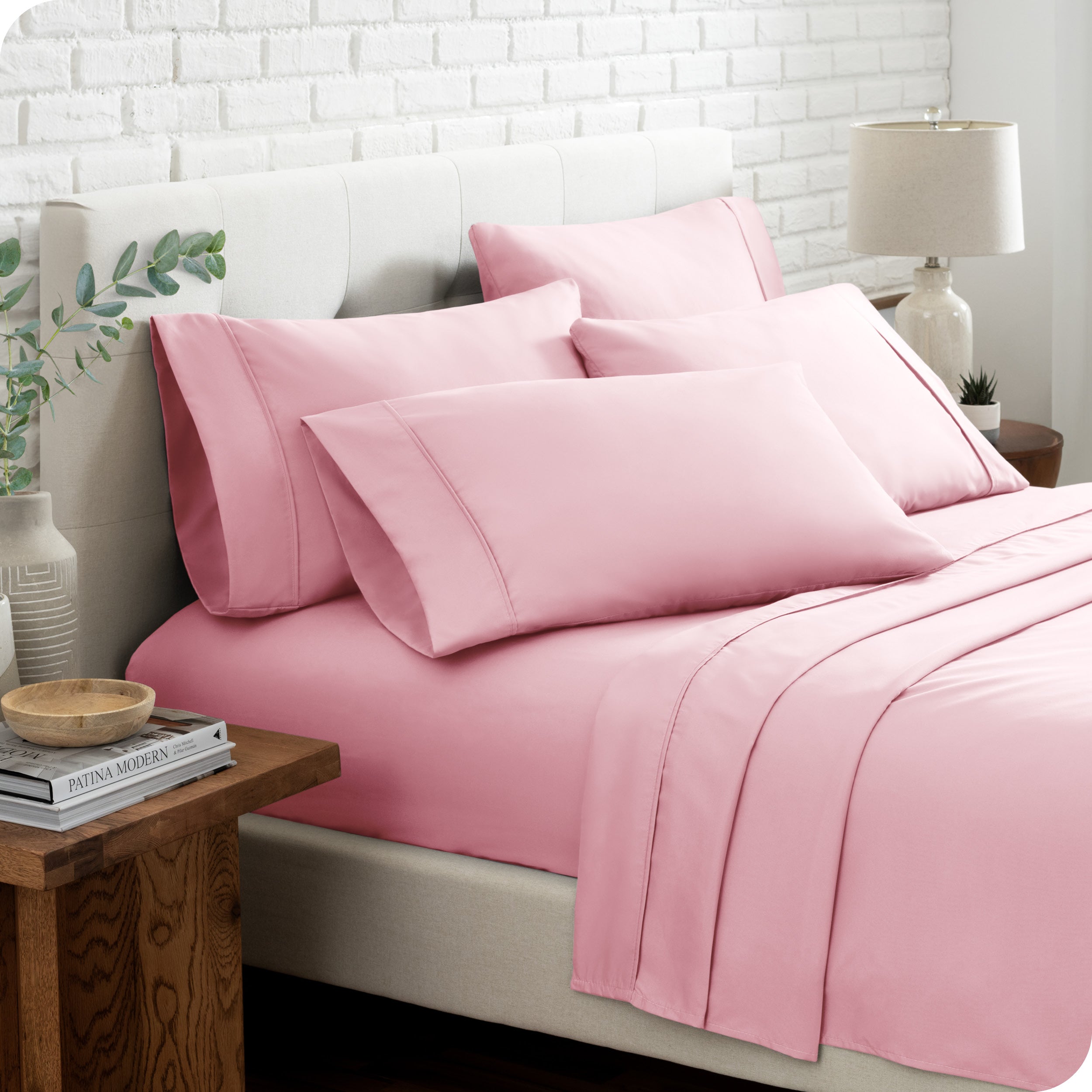 Close up of the microfiber bed sheets on a bed with four pillows.