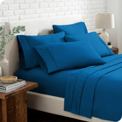 Close up of the microfiber bed sheets on a bed with four pillows.