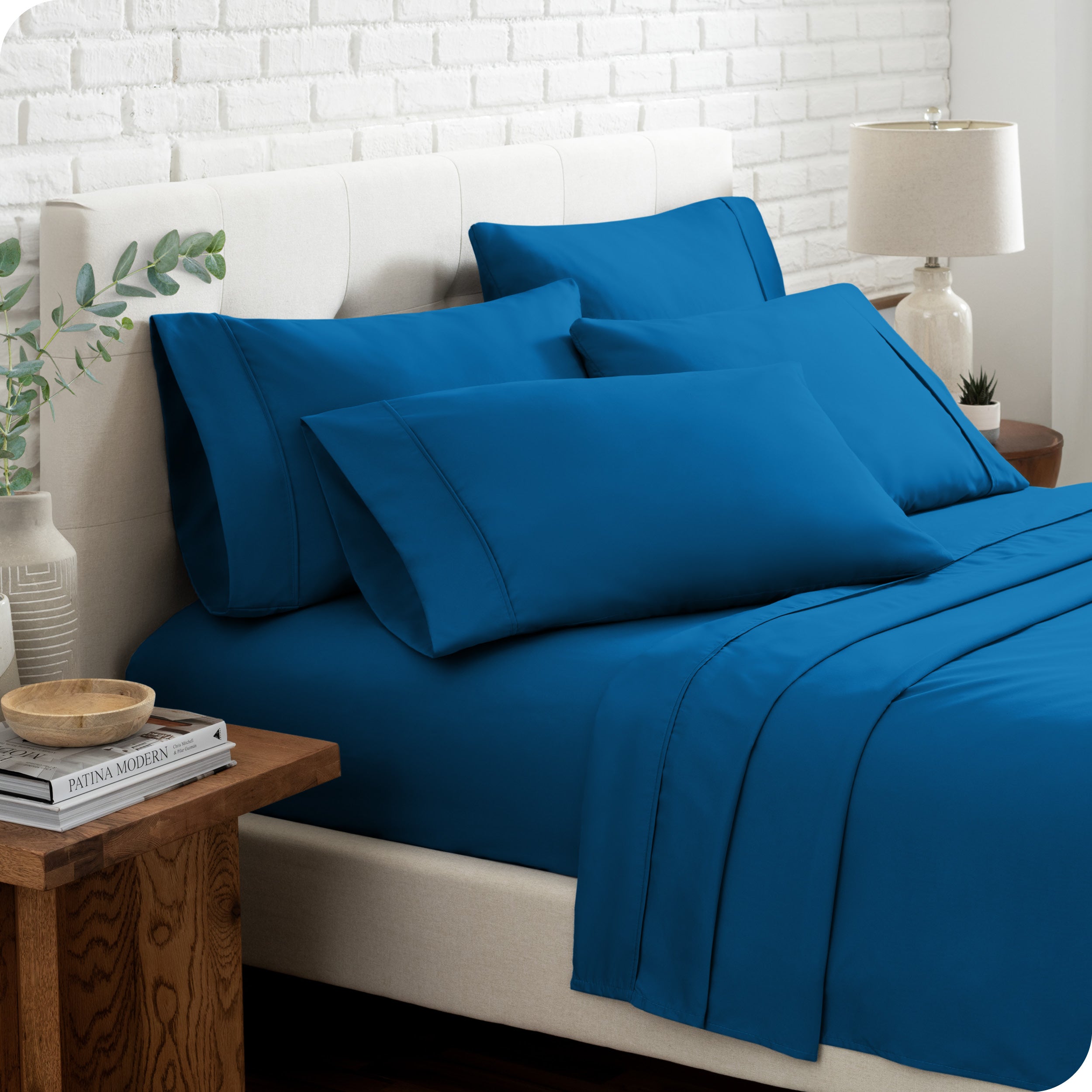 Close up of the microfiber bed sheets on a bed with four pillows.