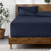 A modern bed with a fitted microfiber sheet made on the mattress.