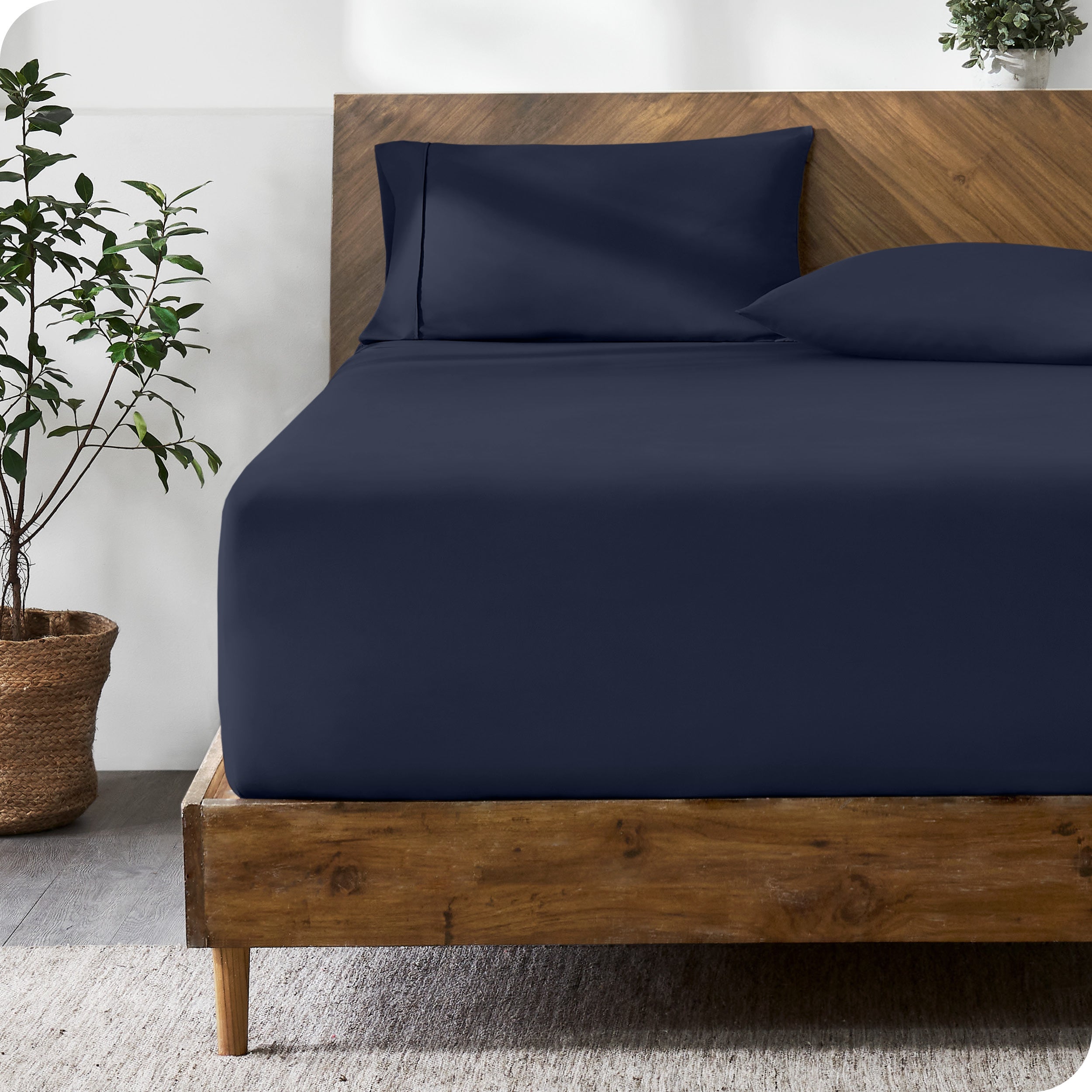 A modern bed with a fitted microfiber sheet made on the mattress.