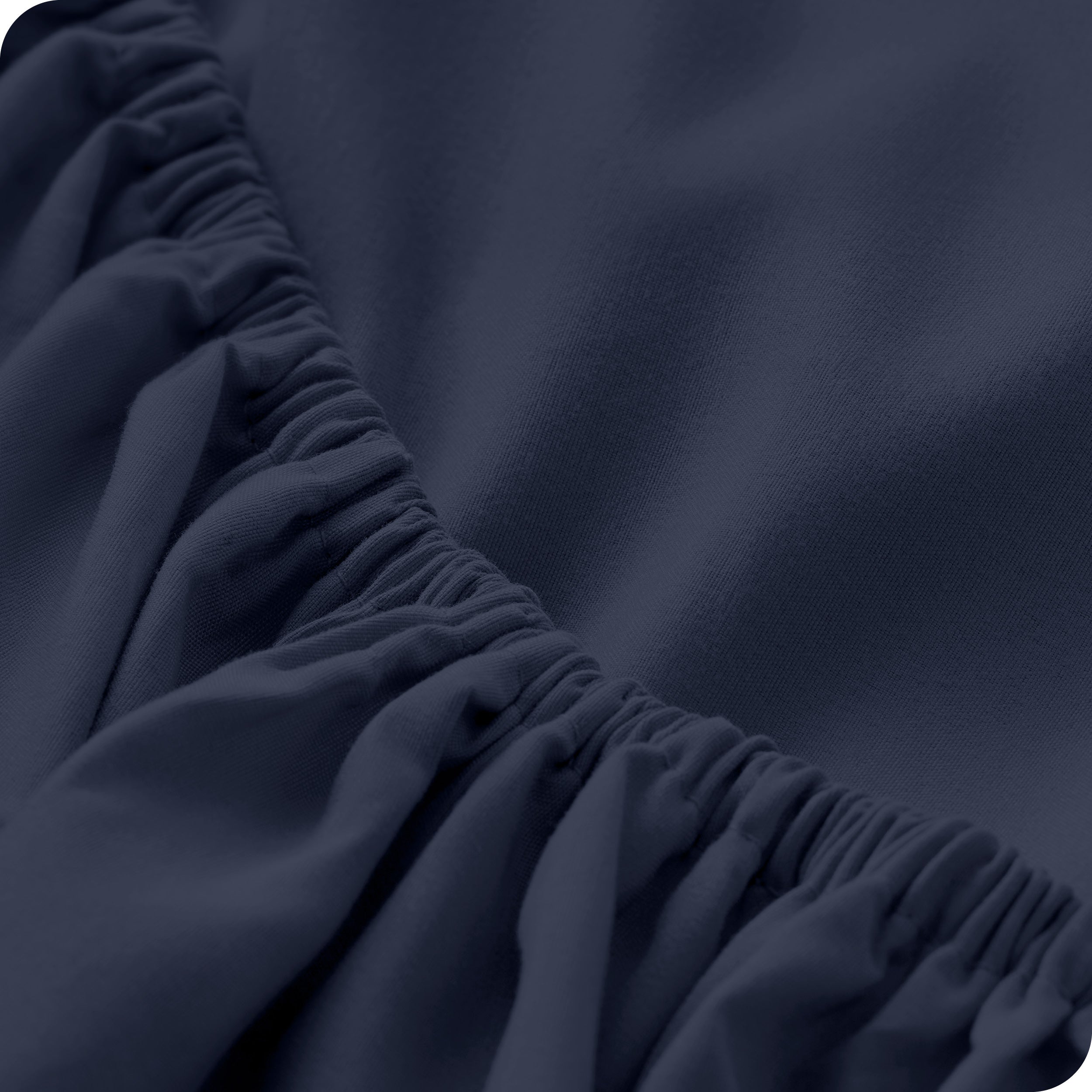 A modern bed with a fitted microfiber sheet on it