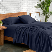 Microfiber sheets and matching pillowcases on a bed next to a large plant