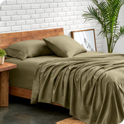 Microfiber sheets and matching pillowcases on a bed next to a large plant