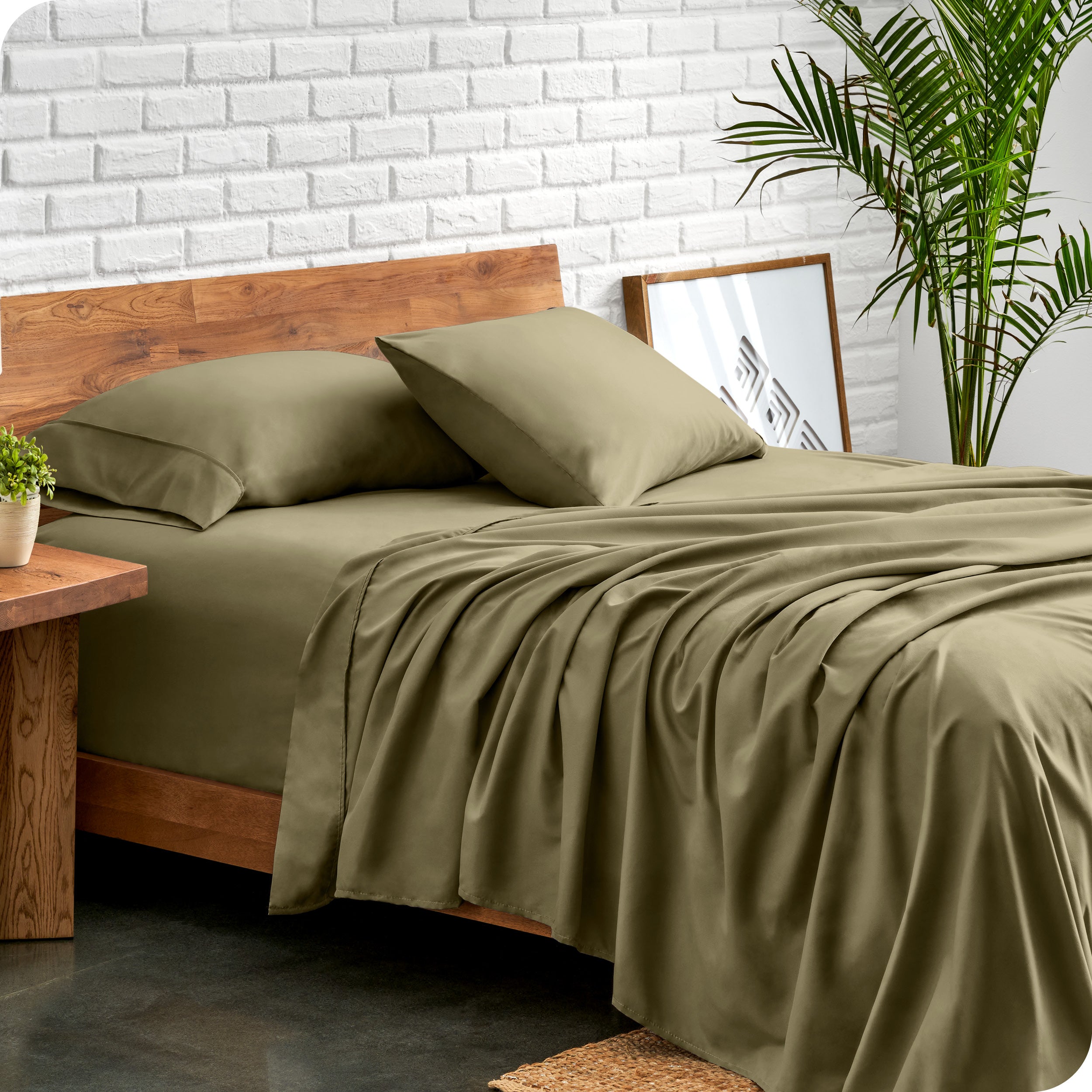 Microfiber sheets and matching pillowcases on a bed next to a large plant